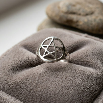 Small silver-plated brass pentagram ring size 8 on a velvet cushion, evoking a peaceful, spiritual vibe with detailed surface micro-texture.