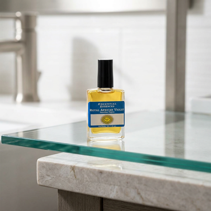 Minimalist scene of Royal African Violet perfume oil bottle on sleek glass shelf in a modern bathroom, with bright natural lighting.