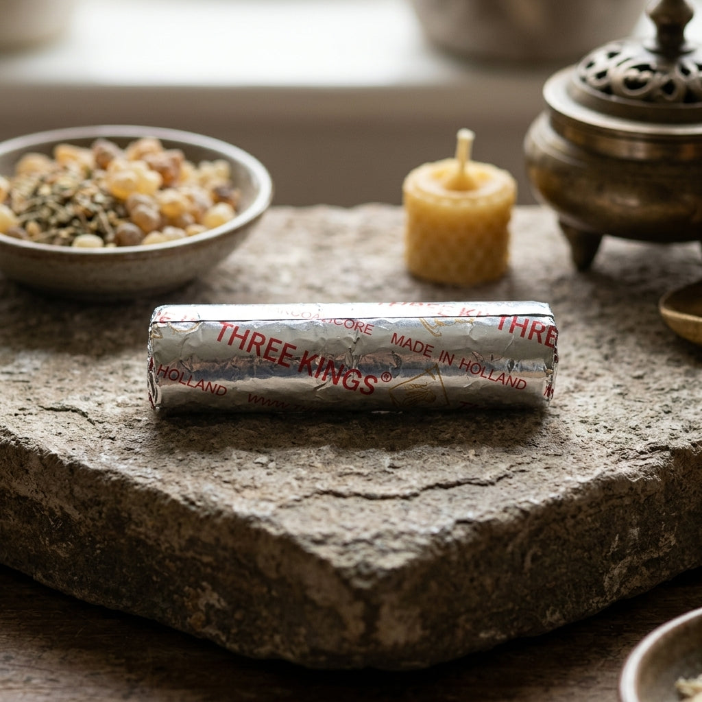 Photorealistic scene of 33mm charcoal tablet on stone altar, surrounded by herbs and candles, emphasizing ritual grounding.