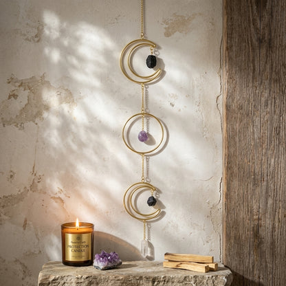 Photorealistic scene of a triple moon wreath with stones hanging on a natural stone wall in a serene spiritual setting, highlighting its detailed craftsmanship.
