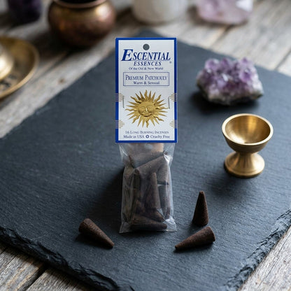 Close-up of small patchouli incense cone on dark stone with ritual objects like amethyst crystals, in a minimalistic scene.