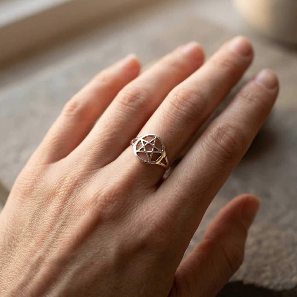 Elegant hand wearing the silver-plated brass pentagram ring size 8 against a natural stone surface, emphasizing its protective symbolism and delicate size.